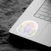 A pastel-colored sticker design featuring a cluster of amethyst-like crystals with soft green foliage and a subtle sunburst background.