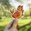 Orange Sea Dragon vinyl sticker, a waterproof vinyl sticker, features a playful cartoon illustration.