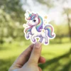 A cute cartoon unicorn with a rainbow mane and tail, sparkling stars, and a golden horn.