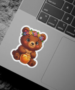 A kawaii illustration of a brown bear wearing a flower crown and holding a jar of honey.