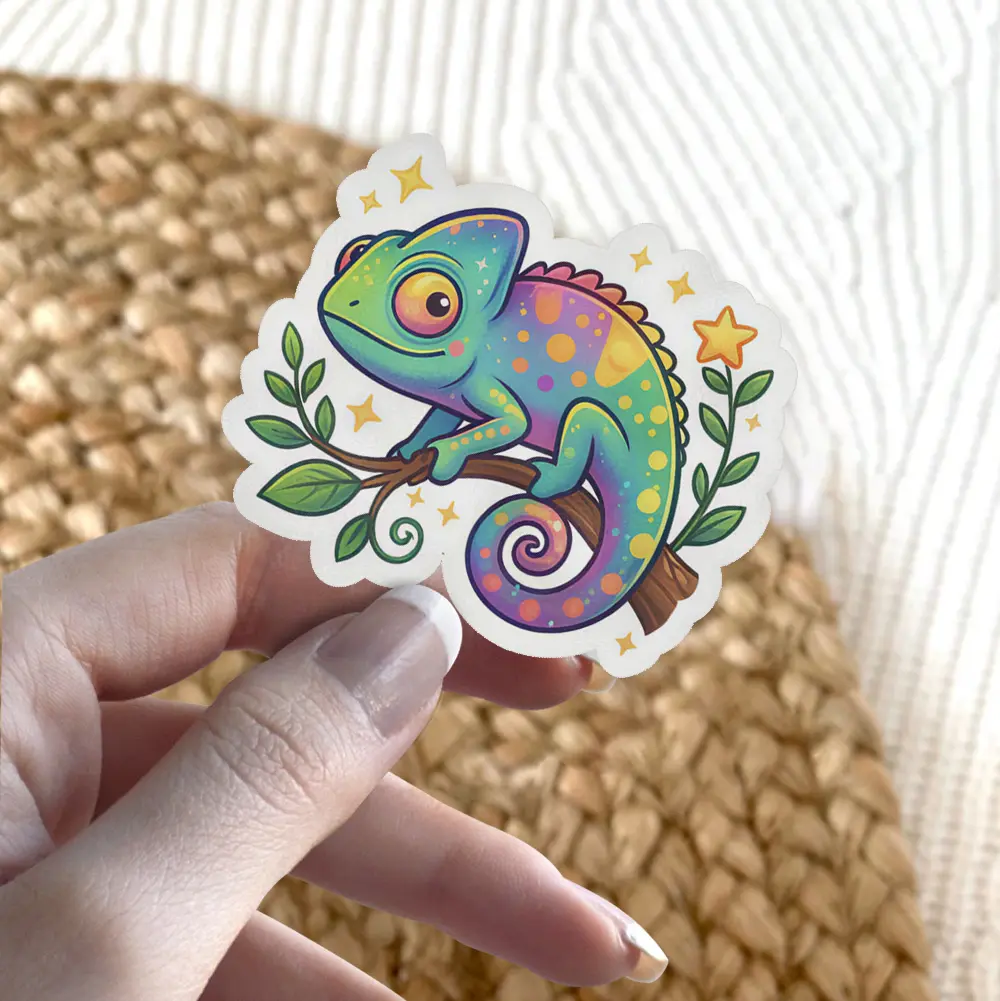 A cute, colorful cartoon chameleon with large eyes sits on a branch adorned with leaves and small stars. This vinyl sticker is ready for application.