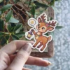 A charming cartoon deer adorned with flowers and holding a lantern, depicted as a sticker.