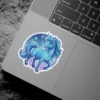 A vibrant blue unicorn with flowing mane and tail gallops beneath a starry night sky, rendered as a glossy sticker.