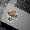 A whimsical mushroom sticker featuring a cap and stem designed with a colorful patchwork quilt pattern and three sewn-on buttons.