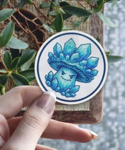 A circular sticker features a cartoon mushroom character with a face, adorned with blue crystals instead of a cap.