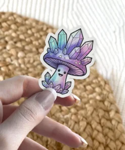 A whimsical vinyl sticker depicts a smiling mushroom character adorned with sparkling amethyst and aquamarine crystals.