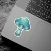 A charming blue mushroom with a friendly face and intricate stem designs, rendered in a watercolor style.