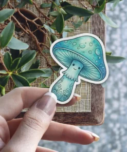 A charming, anthropomorphic blue mushroom with a smiling face and intricate patterns on its stem, depicted as a vinyl sticker.