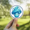 A charming blue mushroom character with a swirled cap and a happy expression, surrounded by bubbles.