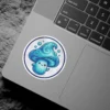 A kawaii blue mushroom with swirling patterns on its cap and stem, featuring a cute face and small bubbles. The sticker has a white background and a blue border.