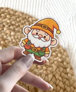 A cute cartoon gnome dressed as a carpenter with tools in its pockets and an orange hat is shown as a vinyl sticker.