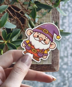 A delightful cartoon gnome sticker featuring a white beard, purple hat, yellow shirt, orange overalls, and a friendly smile.