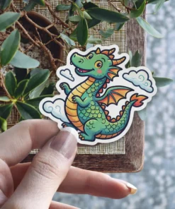 A playful, smiling green dragon with orange scales and wings, surrounded by fluffy white clouds in a cartoon style sticker.