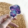 A kawaii mushroom character with a galaxy print on its cap and body, complete with stars and a smiling face.