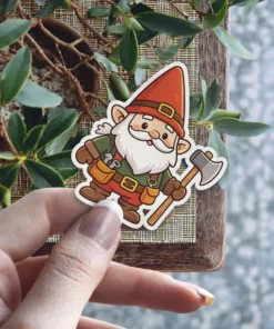 A charming cartoon garden gnome sticker with a white beard, red hat, green shirt, brown tool belt, and an axe.