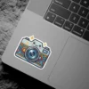 A charming kawaii-style camera sticker featuring a smiling face and a vibrant floral pattern on its body, adorned with sparkling stars.