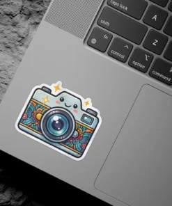 A charming kawaii-style camera sticker featuring a smiling face and a vibrant floral pattern on its body, adorned with sparkling stars.