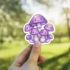 A group of smiling, kawaii-style purple mushrooms with glittery caps and white polka dots.