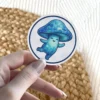 A charming blue mushroom character with a tiled pattern and a smiling face dances happily.