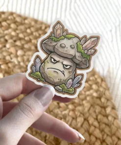 A grumpy mushroom character sticker with crystal growths and moss on its cap and base.