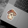 A cheerful, round cartoon mushroom character wearing a red and orange spotted hat. It has a wide smile and closed eyes, with its stubby arms raised.