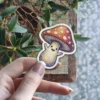 A joyful mushroom character with outstretched arms and a wide smile dances gleefully.