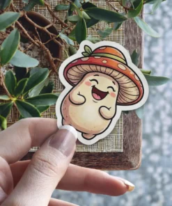 A whimsical sticker features a smiling mushroom character wearing a spotted hat, held by a person's hand.