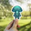 A cute, teal mushroom character wearing intricate, ornate armor.