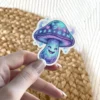 A whimsical purple and blue glowing mushroom sticker featuring a friendly smiling face and mystical glowing runes on its cap.
