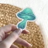 An ornate mushroom sticker with swirling patterns in shades of teal and blue, featuring a detailed stem and cap.