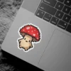 A cute pixel art mushroom with a red cap and white spots, featuring a beige stem and minimalist facial features, outlined in white.