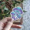 A sticker displays three glowing mushrooms with intricate swirling patterns in shades of purple and teal.