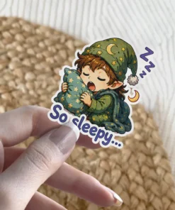 A chibi elf in starry green pajamas and a nightcap is sleeping soundly while hugging a pillow with the text So sleepy below.