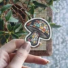 A sticker designed to look like a stained glass mushroom with colorful geometric panes.