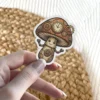 A whimsical steampunk mushroom character with gears and a clock on its cap and body.