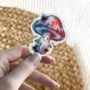 A watercolor-style mushroom character with a smiling face and colorful spots is shown.