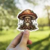 A vinyl sticker depicts a wise old mushroom man with a long beard, resembling a forest spirit.