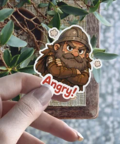 An angry Viking warrior with crossed arms and a stern expression, depicted as a cartoon character. This sticker says 'Angry!' and is a durable vinyl sticker.
