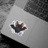 A smiling black bat surrounded by small purple stars and a crescent moon makes for a durable vinyl sticker.