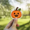 Orange pumpkin sticker, black carved eyes, smiling mouth, green stem leaf, pink blush cheeks, tiny sparkles vinyl sticker.