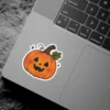 Adorable orange carved pumpkin sticker, smiling face, rosy cheeks, brown stem, green leaf, sparkling white stars, vinyl sticker.