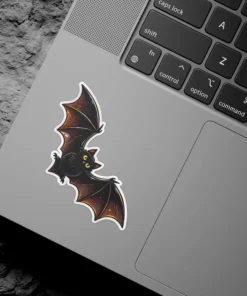 Chibi style black bat, golden yellow eyes, orange wing gradients, detailed digital art, vinyl sticker.