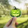 Intense green jack-o'-lantern, bright glowing eyes, sharp jagged smile, eerie cracked texture, dark green stem, vinyl sticker.