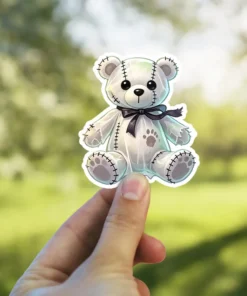 Ghostly white teddy bear, black stitched details, dark bow tie, gothic aesthetic, vinyl sticker