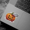 Evil jack-o'-lantern, glowing orange eyes, chainsaw impaled in head, blood splattered around, green stem, horror vinyl sticker.
