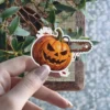 A spooky, carved jack-o-lantern with a rusty chainsaw running through it and blood splatters. This durable vinyl sticker is perfect for laptops or water bottles.