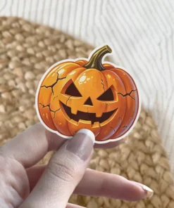 Orange cracked Jack-o'-lantern, triangular eyes, jagged smile, green stem, white border, vinyl sticker.