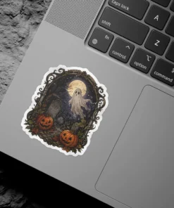 Whimsical ghost, full moon, two grinning jack-o'-lanterns, weathered gravestones, eerie bare trees, ornate dark frame, vinyl sticker.