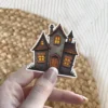 Haunted house, glowing windows, boarded up doors, stone texture, gothic architecture, dark aesthetic, vinyl sticker