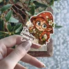 A charming sticker features a red-haired elf girl with glasses and a mushroom hat, pointing up with a speech bubble 'I'm reminding you!' vinyl sticker.